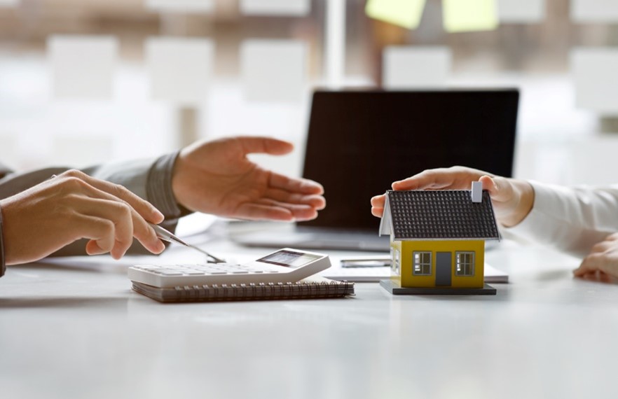 Mortgage advisor at a desk across from a house buyer